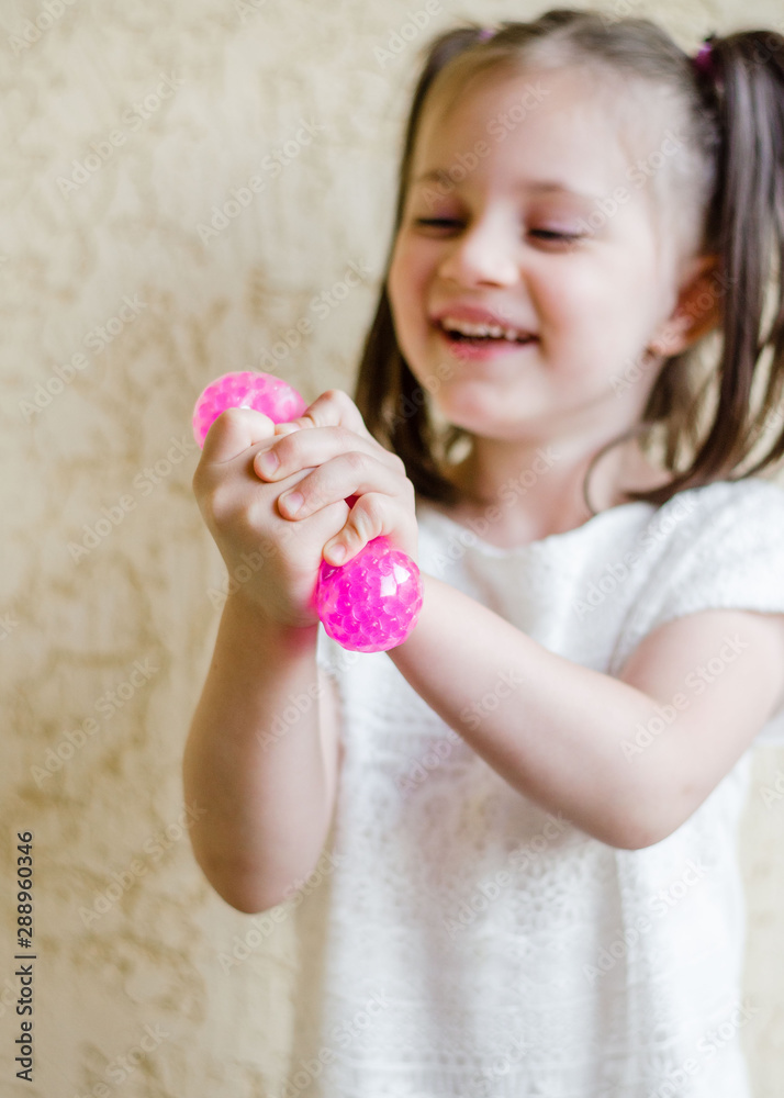 Child girl holding stress relief grape balls. squeezing balls, mesh squishy balls in kid's hands Child girl holding stress relief grape balls. squeezing balls, mesh squishy balls in kid's hands