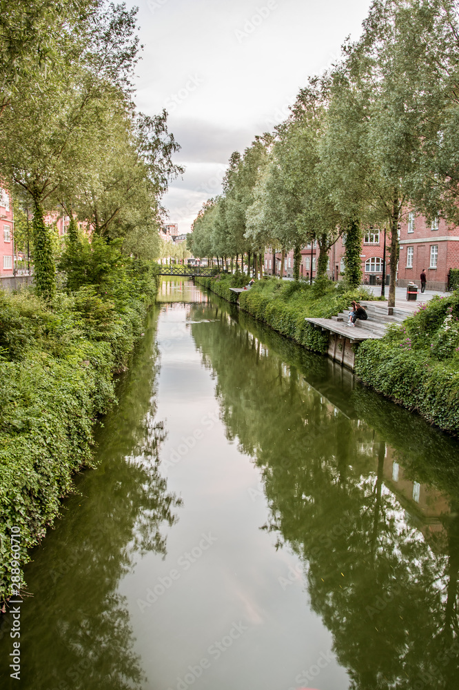 The canal in Aarhus flows gently through the city and the trees reflecting in the water