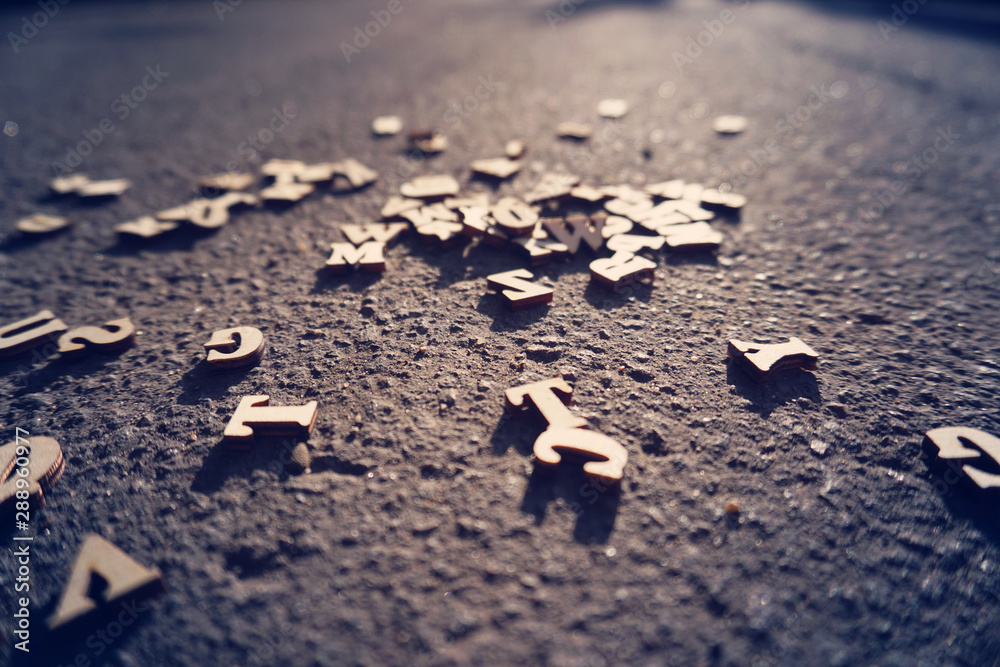 Letters fall on the asphalt, tinted photo of the English alphabet, learning and science. Letters fall on the asphalt, tinted photo of the English alphabet, learning and science.
