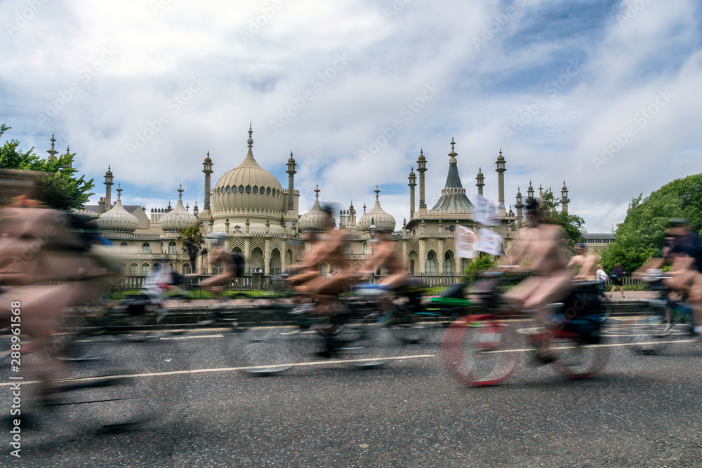 Obraz premium blurred naked cyclists going past brighton pavillion