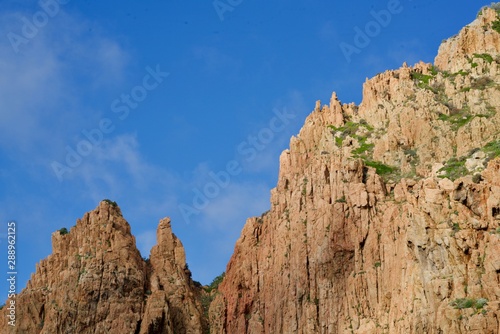 Greened beige cliff under a perfect blue sky
