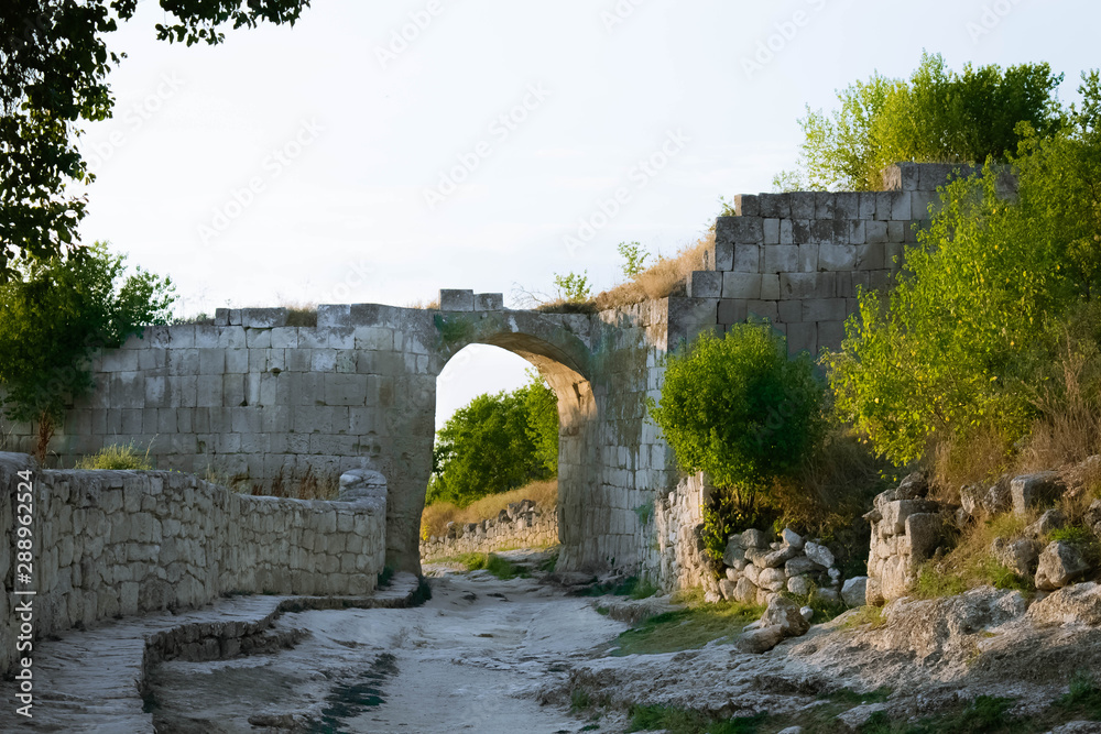 The ruins of the wall with the arch of the ancient cave city