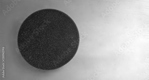 Black foam pad circle against white background and light gray color gradient, free space for text