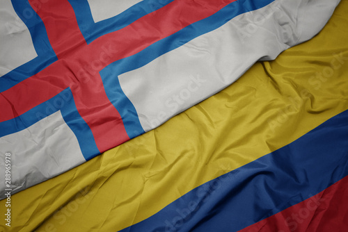 waving colorful flag of colombia and national flag of faroe islands.