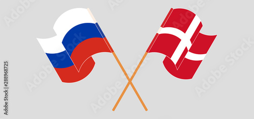 Crossed and waving flags of Russia and Denmark