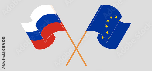 Crossed and waving flags of Russia and the EU