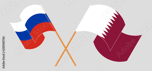 Crossed and waving flags of Russia and Qatar