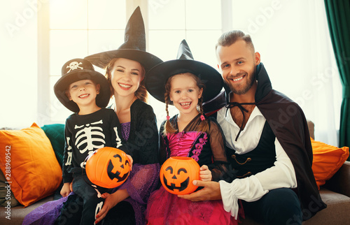 happy family mother father and children in costumes on Halloween