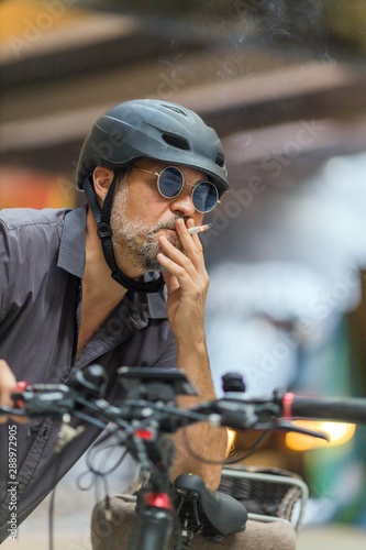 portrait of a cyclist smoking cigarette