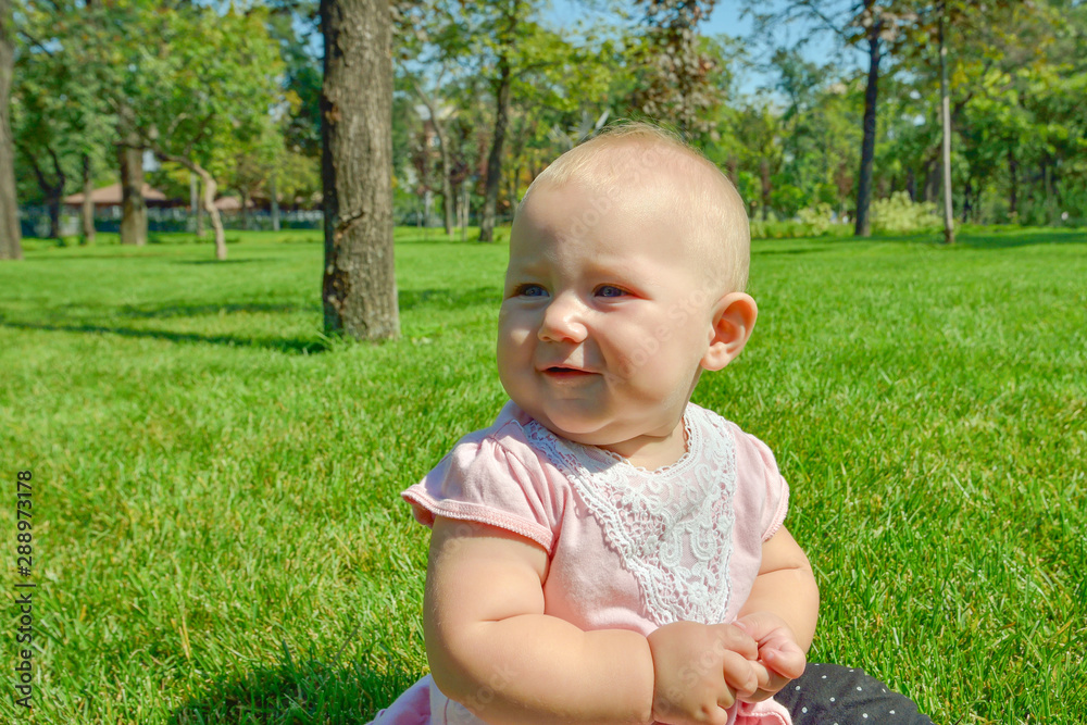 A child on the green grass is played in the park. A child on the green grass is played in the park.