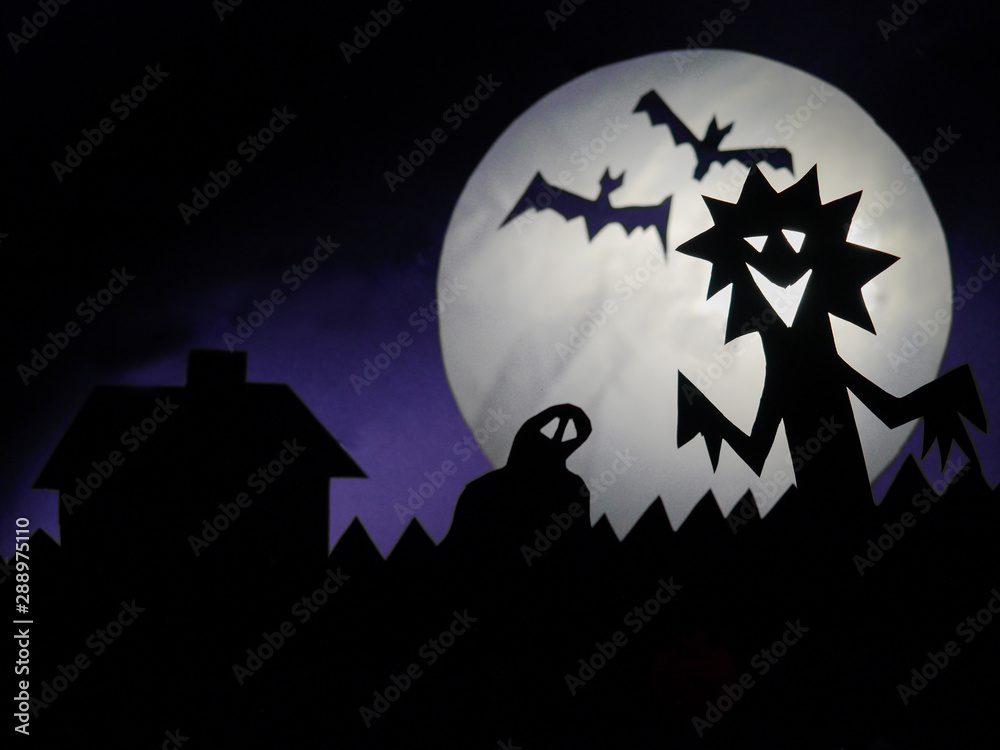 Halloween scene, Scary creatures silhouettes on a fool moon background. Funny monster, ghost and two bats in flight, Copy space, Selective focus,