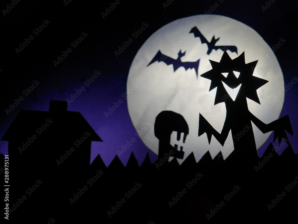 Dark Halloween season background with moon in the background and scary creatures silhouettes. Alien scull, bats, and funny monster.