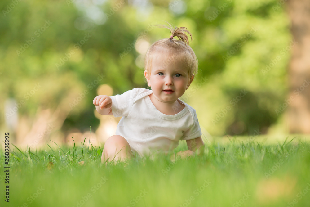 baby girl in a white sandpit on the green grass playing pyramid baby girl in a white sandpit on the green grass playing pyramid