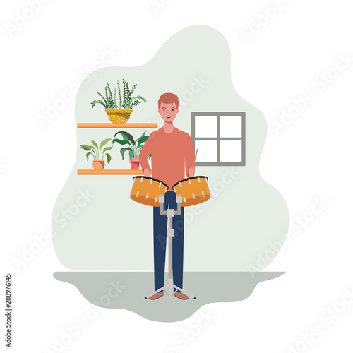 young man with timpani and houseplants of background