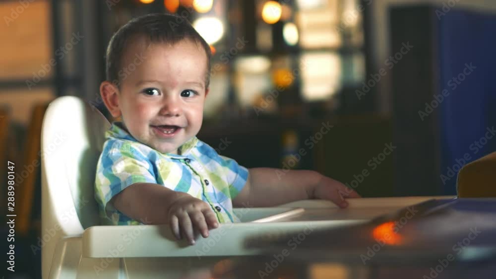 Kid sits in a children's chair, refuses to eat porridge, is capricious. Kid sits in a children's chair, refuses to eat porridge, is capricious.