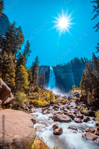 Landscape of Vernal Falls from the bottom one summer morning and the sun above. California, United States photo