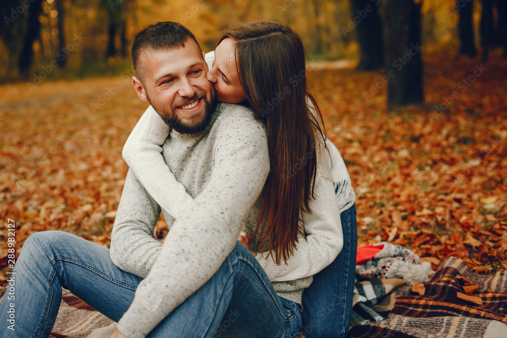 Fototapeta premium Couple in a park. Family in a golden forest. Man with a beard