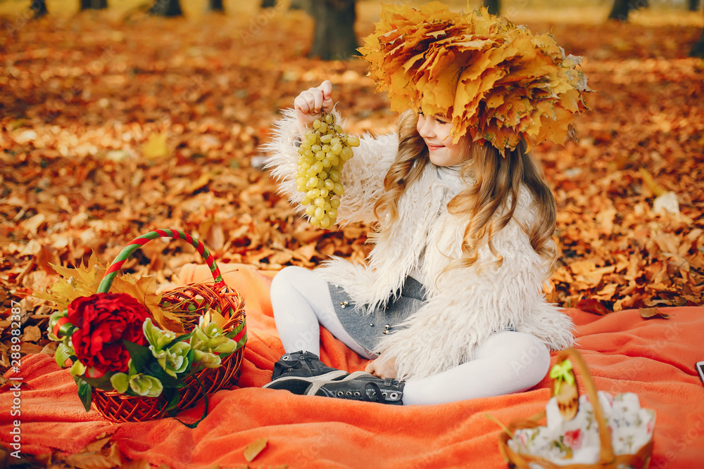 Cute child in a autumn park. Elegant little lady with fruits Cute child in a autumn park. Elegant little lady with fruits