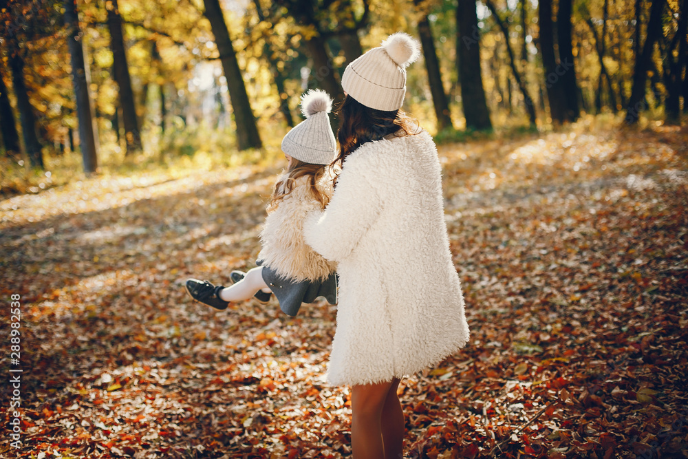 Fototapeta premium Beautiful mother with daughter. Family in a autumn park. Golden autumn