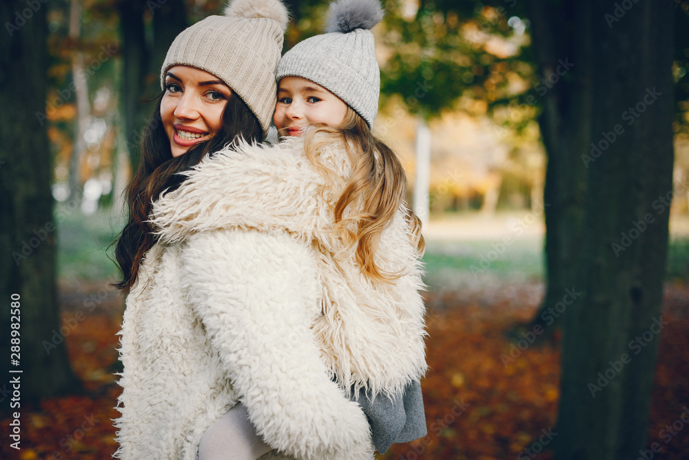 Beautiful mother with daughter. Family in a autumn park. Golden autumn
