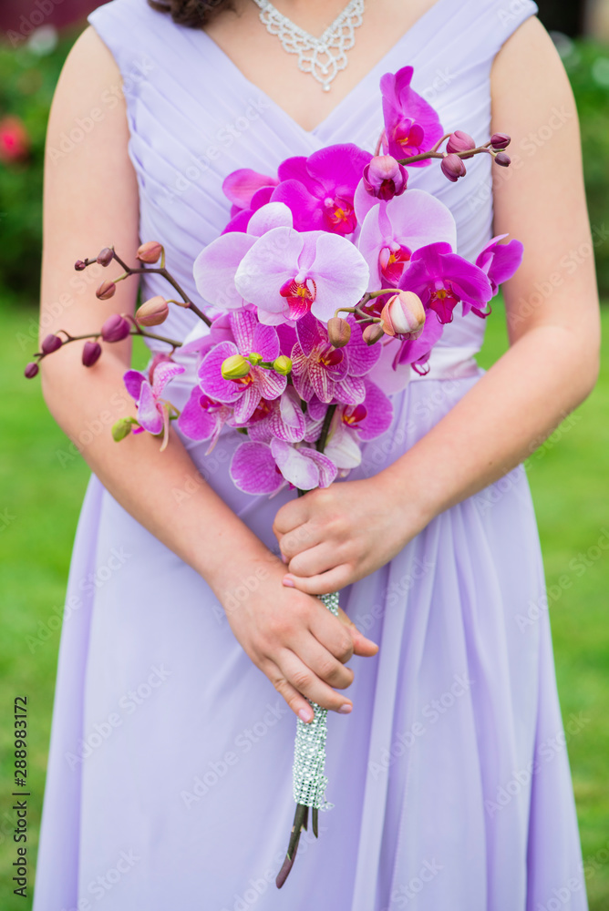 bridesmaid holding bouquet, girl in lavender gown holding a bouquet of fuchsia orchids, bridal party details, wedding day flowers bridesmaid holding bouquet, girl in lavender gown holding a bouquet of fuchsia orchids, bridal party details, wedding day flowers