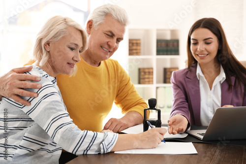 Female notary working with mature couple in office photo