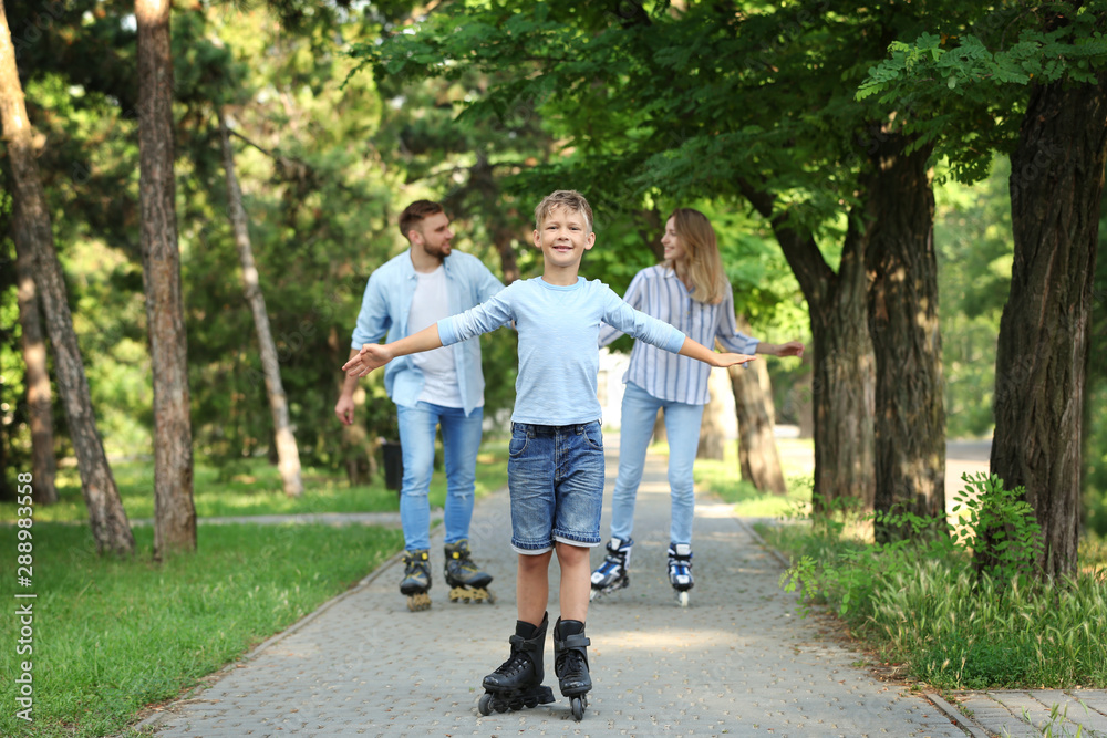 Young happy family roller skating in summer park Young happy family roller skating in summer park