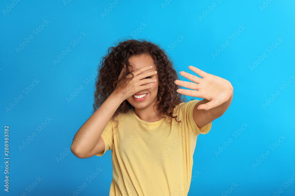 Young African-American woman being blinded on blue background Young African-American woman being blinded on blue background