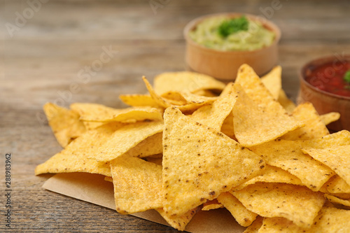 Mexican nacho chips on wooden table, closeup
