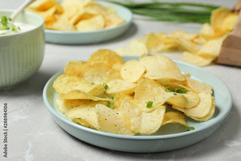 Chips and sour cream dressing on light grey table Chips and sour cream dressing on light grey table