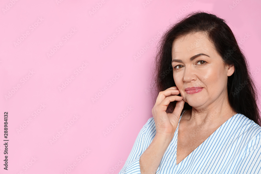 Portrait of mature woman with beautiful face on pink background. Space for text Portrait of mature woman with beautiful face on pink background. Space for text