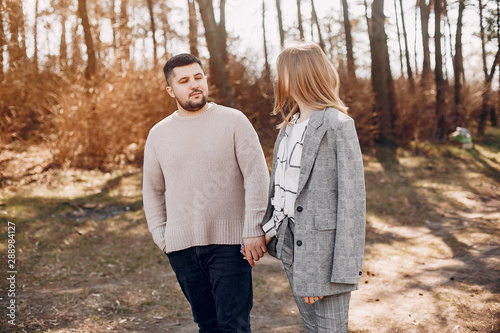 Couple in a park. Blonde in a gray jacket. Man with a beard © prostooleh