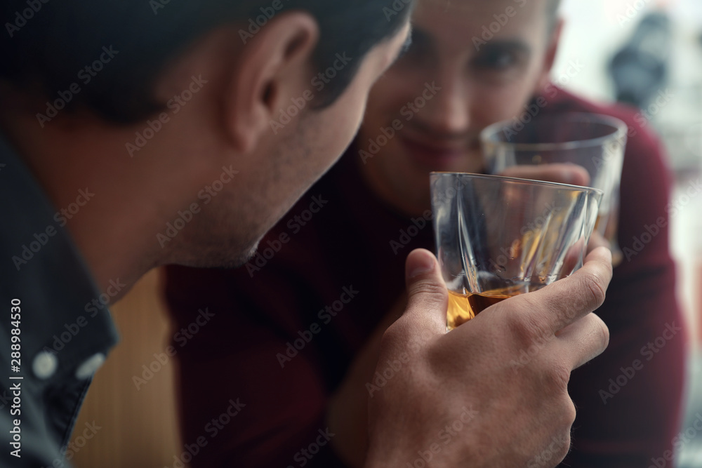 Young men drinking whiskey together in bar Young men drinking whiskey together in bar