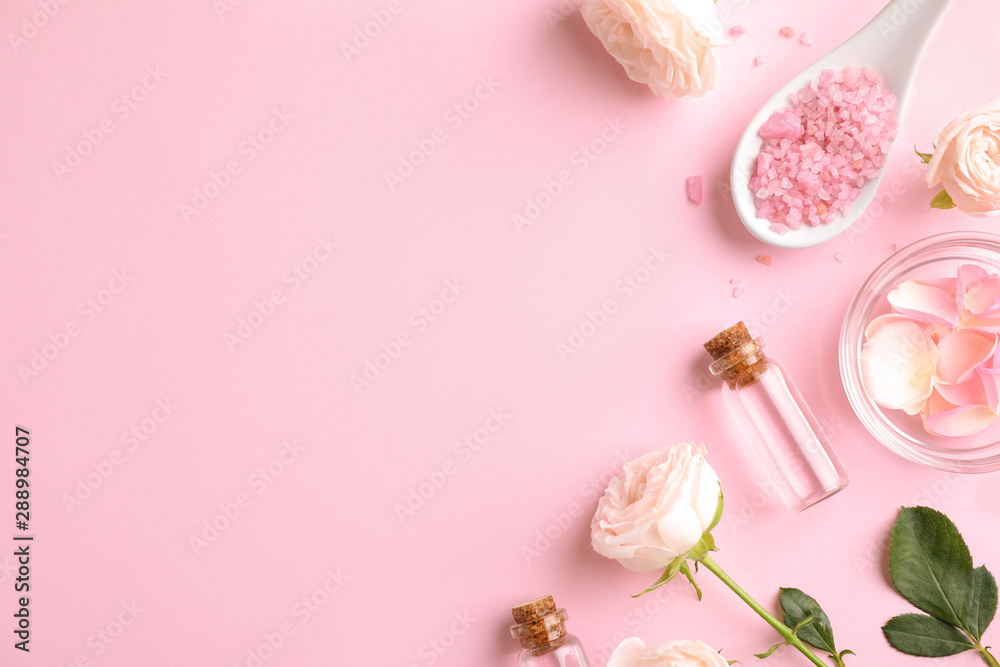 Flat lay composition with rose essential oil on pink background, space for text
