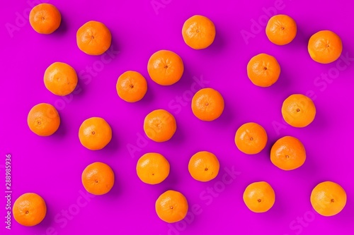 Fruit pattern of fresh orange tangerine or mandarin on lilac background. Flat lay, top view. Pop art design, creative summer concept. Citrus in minimal style. © Natika