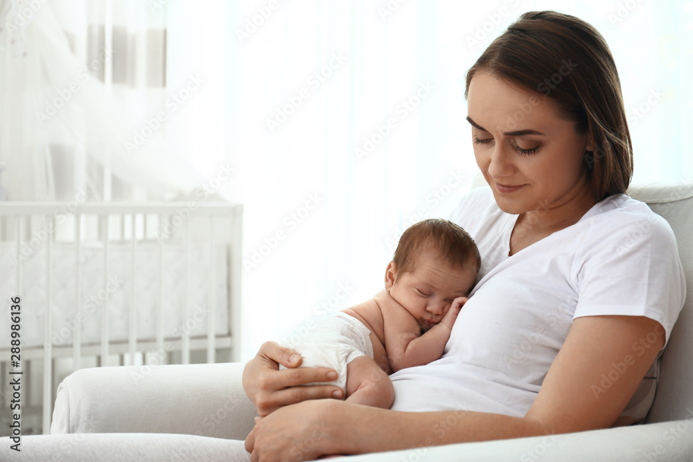 Young mother with her little baby sitting in armchair at home. Space for text Young mother with her little baby sitting in armchair at home. Space for text