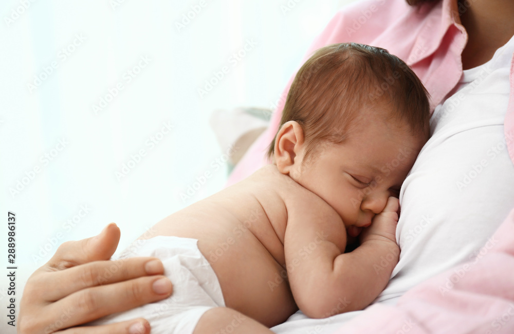 Young mother with her little baby on light background - obrazy, fototapety, plakaty 