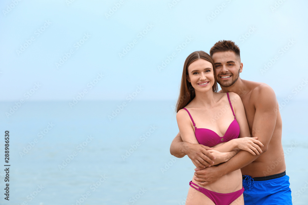 Young woman in bikini with her boyfriend on beach, space for text. Lovely  couple Stock Photo | Adobe Stock