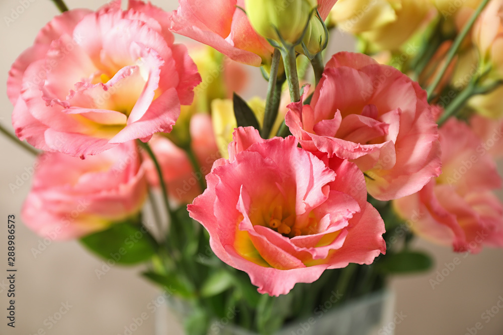Obraz premium Beautiful Eustoma flowers against beige background, closeup