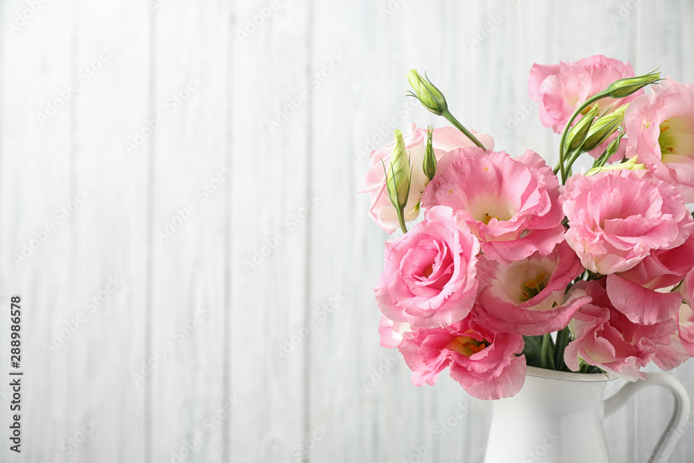 Eustoma flowers in vase near white wall, space for text Eustoma flowers in vase near white wall, space for text