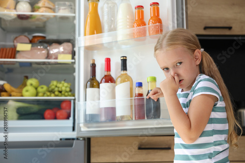 Canvas Print Girl feeling bad smell from stale products in refrigerator at home