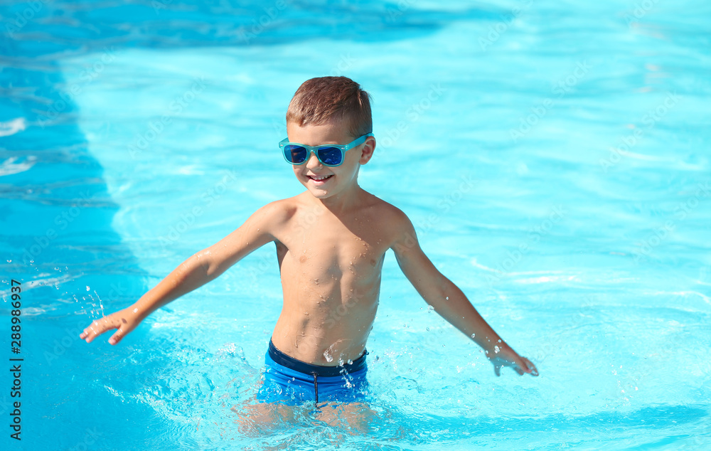 Happy little boy having fun in swimming pool