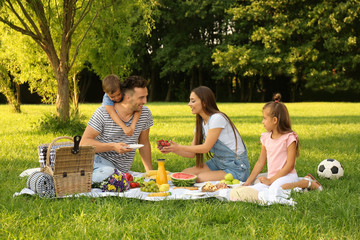 Happy family having picnic in park on sunny summer day