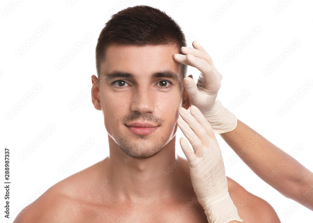 Doctor examining man's face for cosmetic surgery on white background Doctor examining man's face for cosmetic surgery on white background