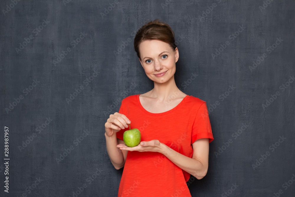 Portrait of happy young woman holding green apple in hands Portrait of happy young woman holding green apple in hands