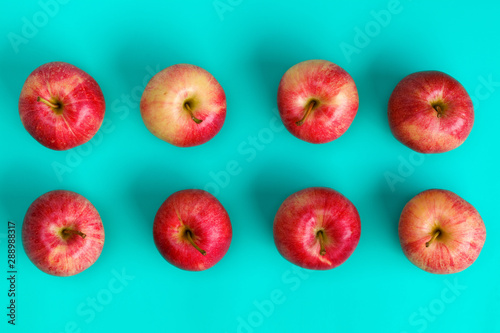 Owocowy wzór czerwony jabłko na błękitnym tle. Leżał płasko, widok z góry. Projekt pop-artu, koncepcja kreatywnego lata. Tło żywności