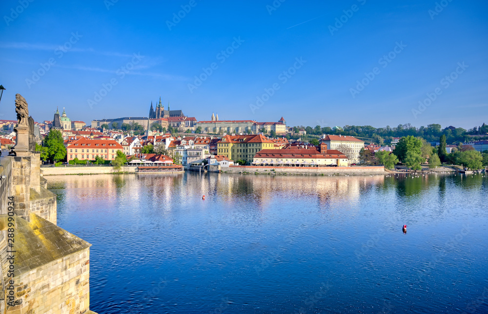 A view across the Charles Bridge and the Vltava River to Prague Castle and St. Vitas Cathedral in Prague, Czech Republic.