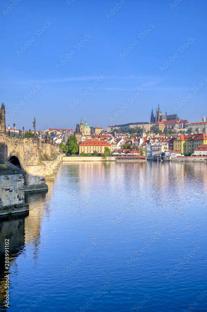 Obraz premium A view across the Charles Bridge and the Vltava River to Prague Castle and St. Vitas Cathedral in Prague, Czech Republic.