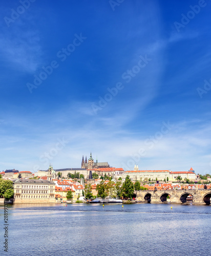 A view across the Charles Bridge and the Vltava River to Prague Castle and St. Vitas Cathedral in Prague, Czech Republic.