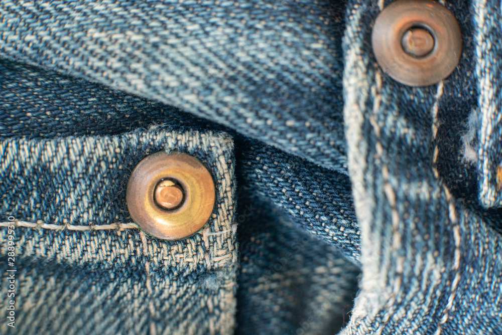 Micro detail of rivets on denim blue jeans Micro detail of rivets on denim blue jeans